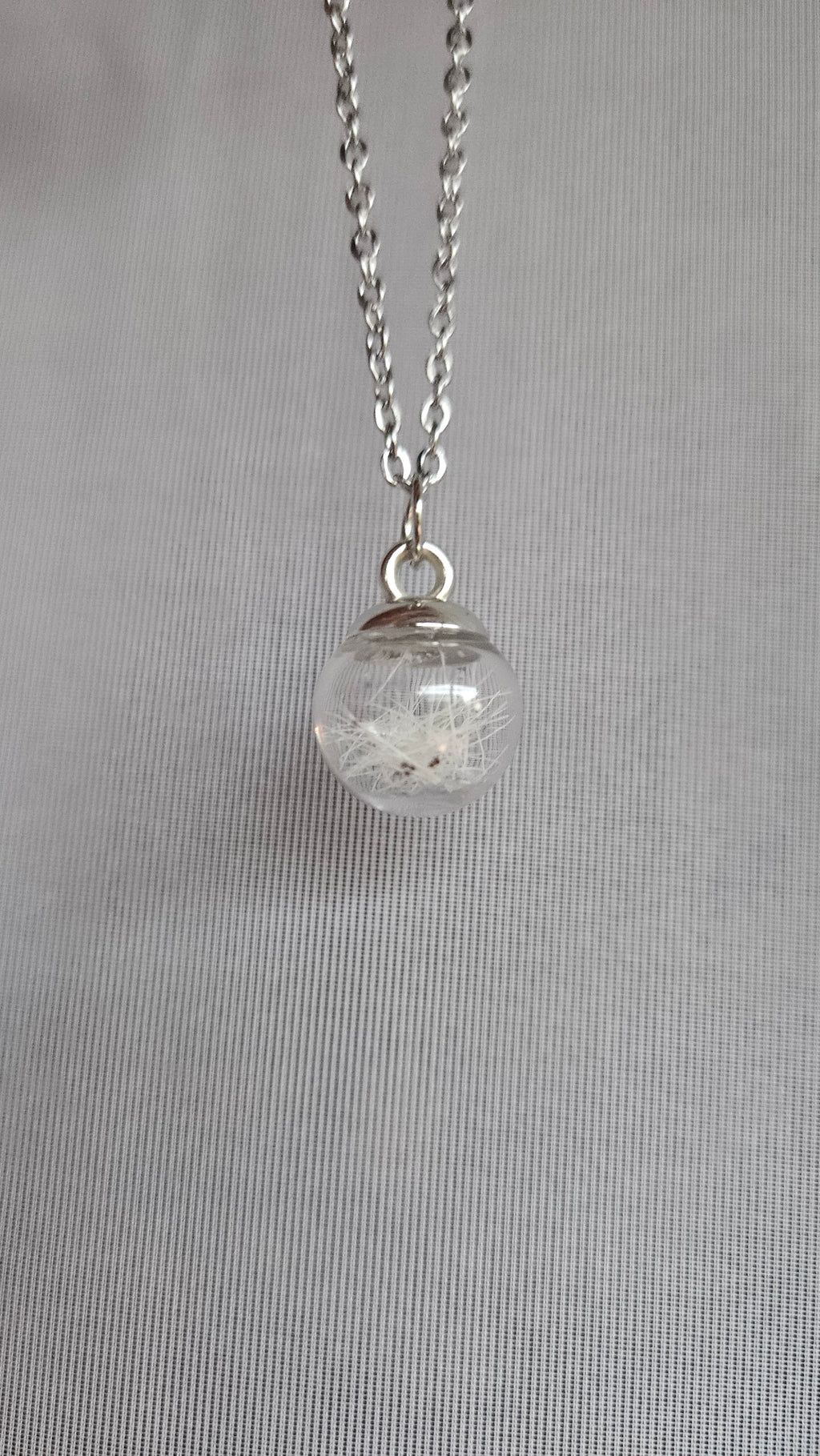 Glass bead filled with animal hair and chain