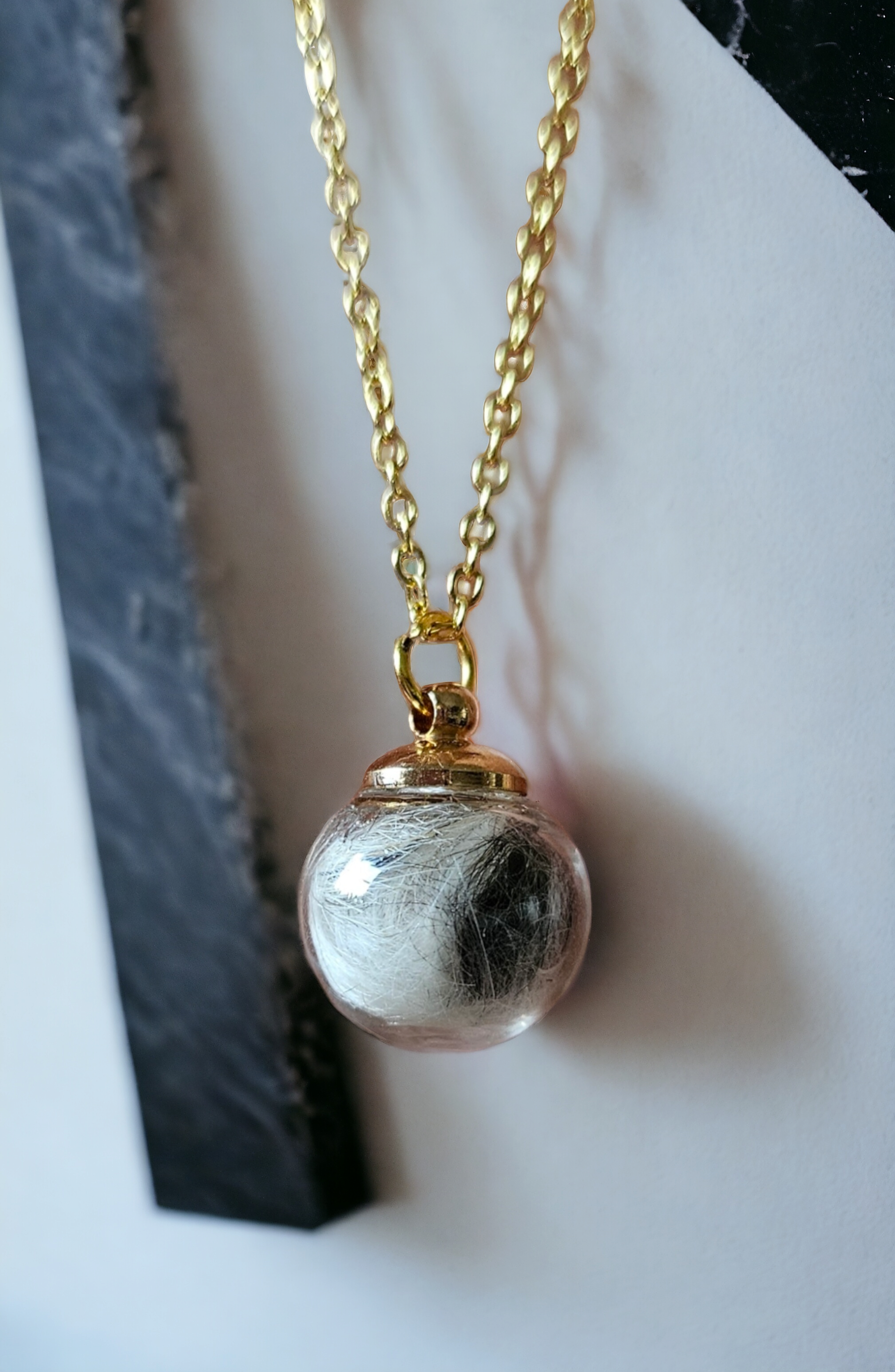 Glass bead filled with animal hair and chain